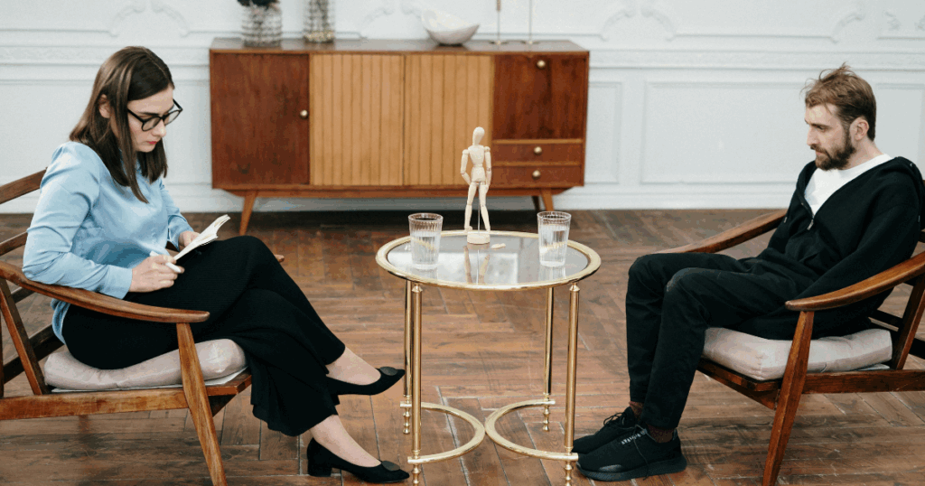 image - Treat Mental Health California Gestalt Therapy session: Therapist and patient in chairs, discussing present moment awareness and personal growth.