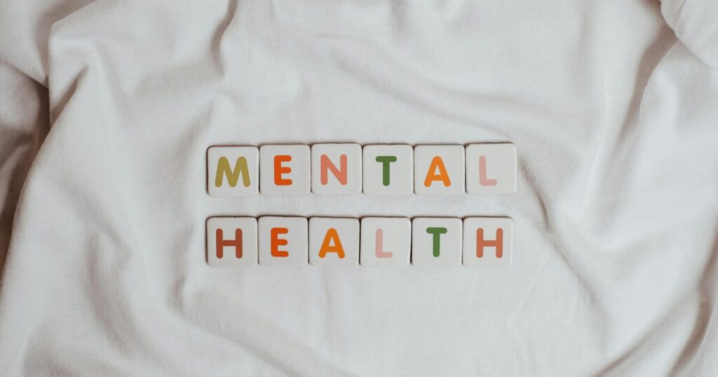 image - Treat Mental Health California Tiles spell out 'MENTAL HEALTH' on a white fabric background with colorful letters on each tile.