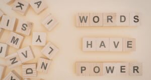 - Treat Mental Health California Wooden letter tiles spell 'WORDS HAVE POWER' on a beige background with scattered letters to the left.