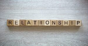 - Treat Mental Health California Wooden alphabet blocks spelling RELATIONSHIP on a light wood surface.