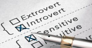 Close-up of a personality checklist with checked boxes for Extrovert and Introvert; a fountain pen rests near the selections.