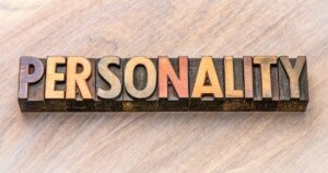 Word 'PERSONALITY' formed by vintage wooden letterpress blocks on a light wooden surface.
